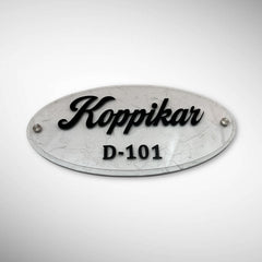 An elegant oval nameplate featuring a marble-style finish with raised black lettering | Koppikar