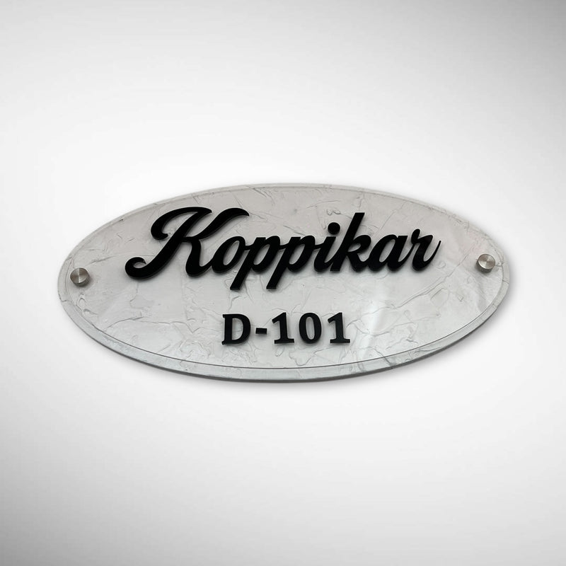 An elegant oval nameplate featuring a marble-style finish with raised black lettering | Koppikar