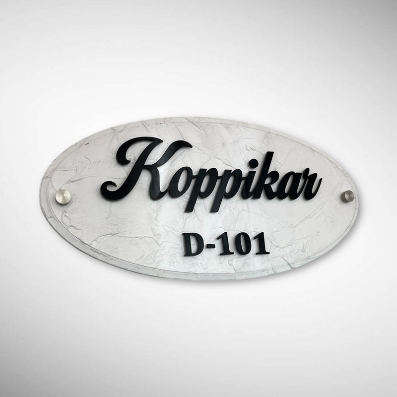 An elegant oval nameplate featuring a marble-style finish with raised black lettering | Koppikar