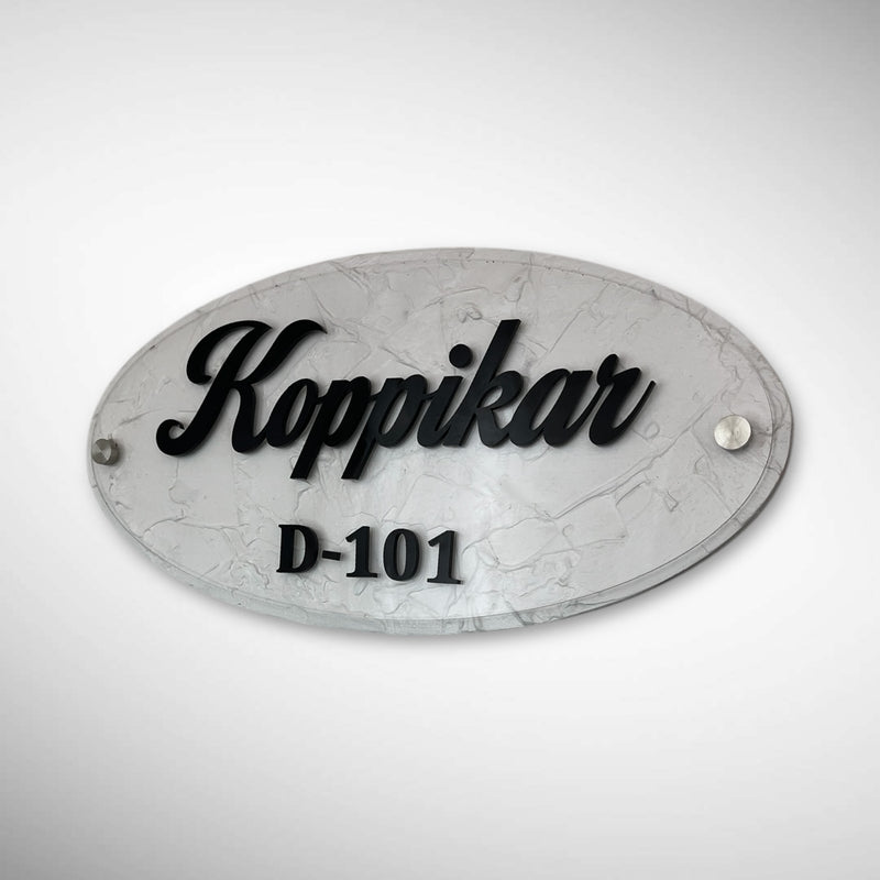 An elegant oval nameplate featuring a marble-style finish with raised black lettering | Koppikar