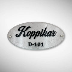 An elegant oval nameplate featuring a marble-style finish with raised black lettering | Koppikar