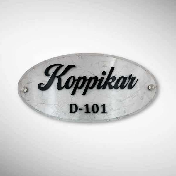 An elegant oval nameplate featuring a marble-style finish with raised black lettering | Koppikar