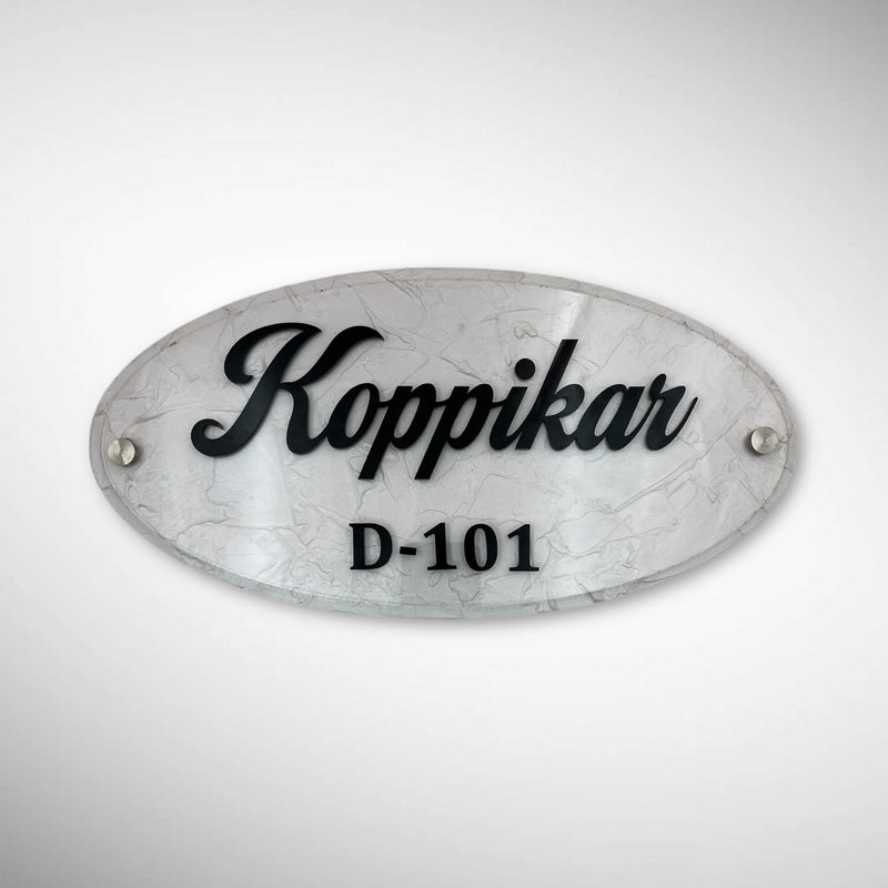 An elegant oval nameplate featuring a marble-style finish with raised black lettering | Koppikar