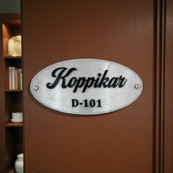 An elegant oval nameplate featuring a marble-style finish with raised black lettering | Koppikar