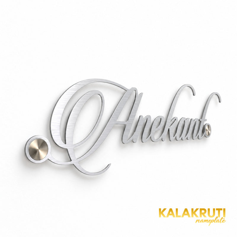 Anekant silver-tone script nameplate from the left, showing the thin cut-out lettering and mounting caps