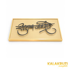 Subhash Jamdade Marathi nameplate, oblique detail showing raised dark calligraphy and the gold-tone border