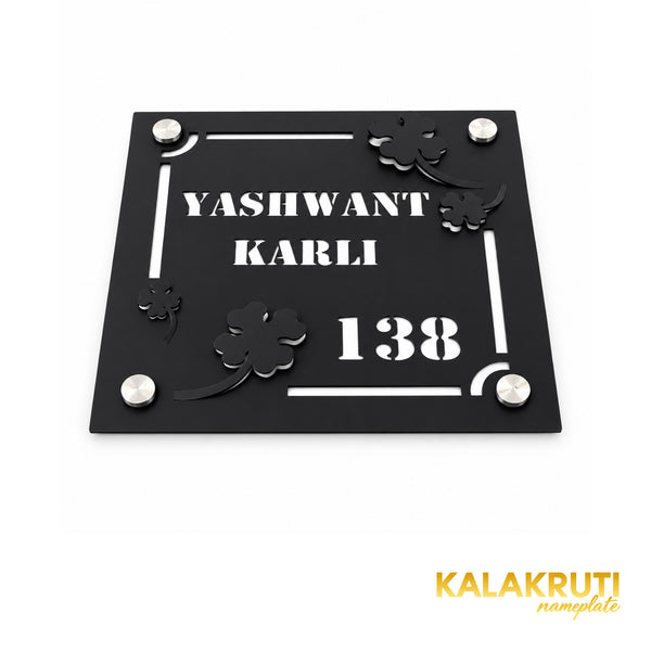 Yashwant Karli square black nameplate, oblique detail of layered flowers, cutout text and four mounting caps