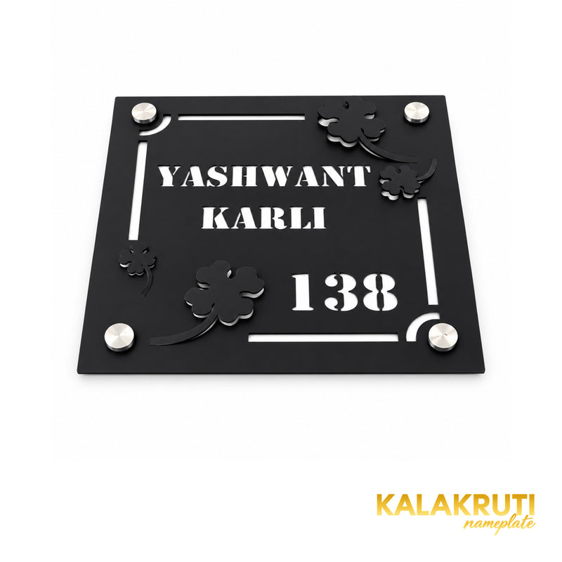 Yashwant Karli square black nameplate, oblique detail of layered flowers, cutout text and four mounting caps
