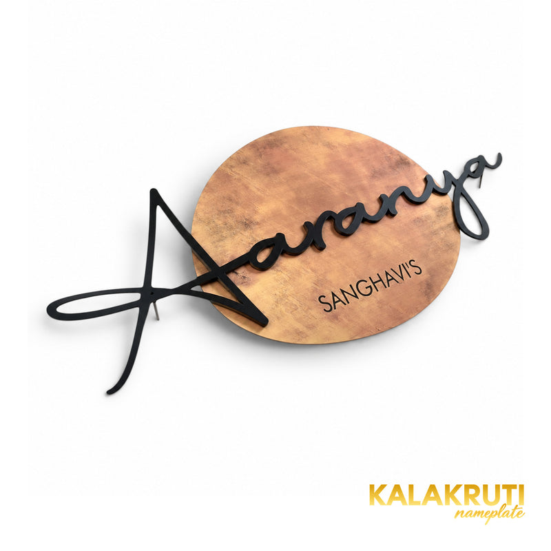 Aaranya copper-tone round nameplate, original oblique view showing raised black script and surname line