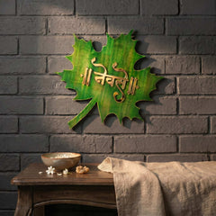 Green leaf LED nameplate with gold Devanagari lettering, installed view with LED off