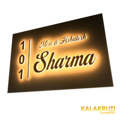 Mira & Ashutosh Sharma 101 white acrylic LED nameplate — Right angle warm LED on in low ambient light