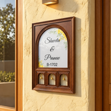 Brown wooden Shweta and Pranav nameplate with three brass bells