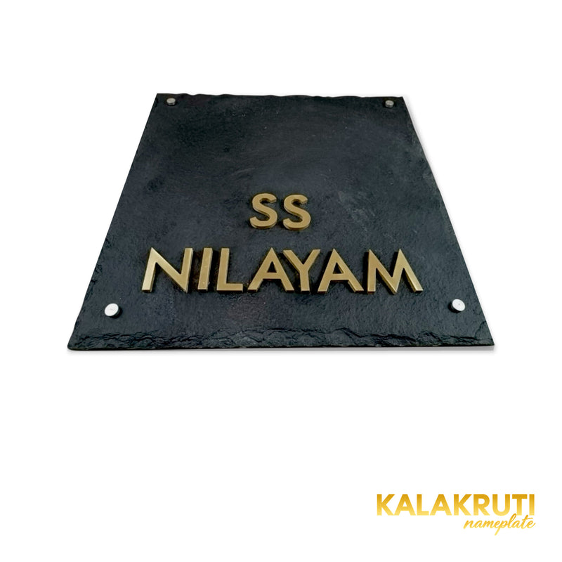 SS Nilayam nameplate, original low table camera showing brass letters and thin slab on a white studio background