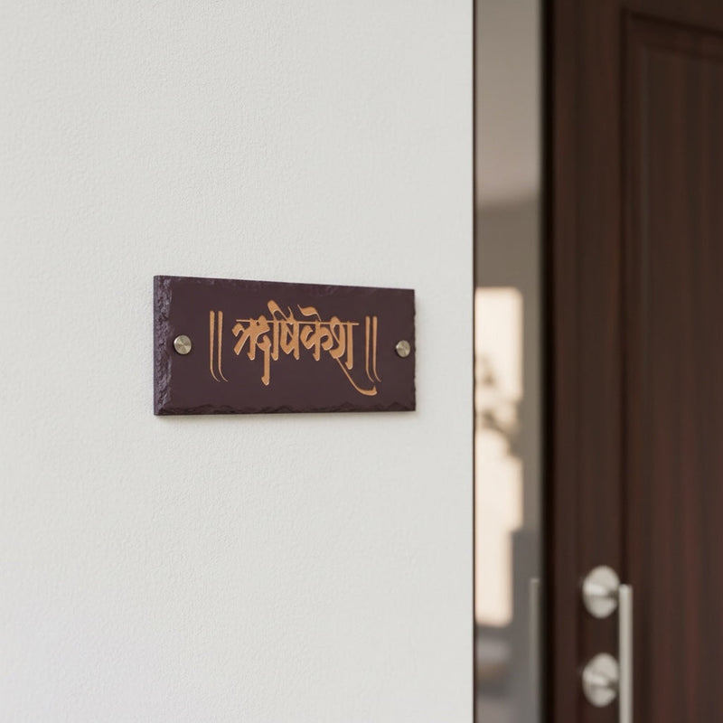 Hrishikesh engraved brown stone nameplate installed beside an apartment entrance door