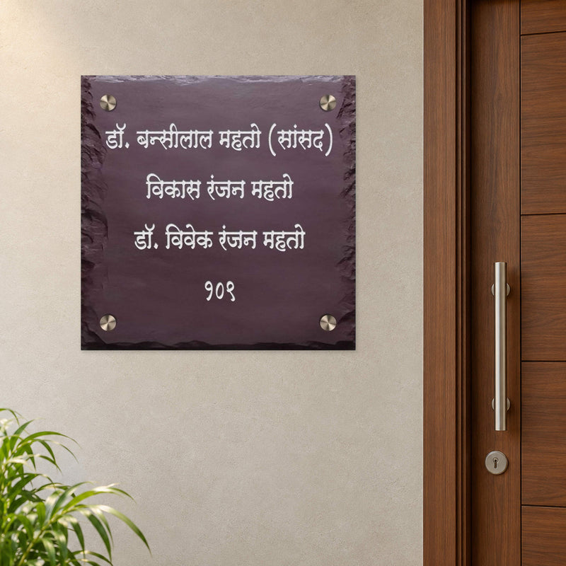 Mahato family engraved brown stone nameplate shown installed level beside an apartment entrance