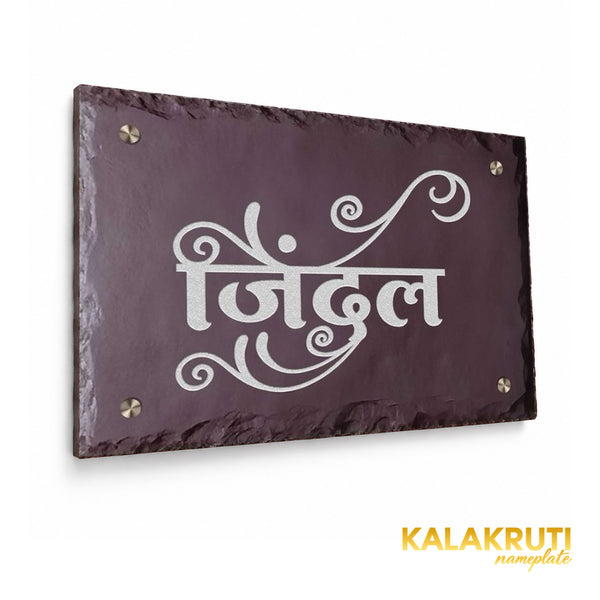 Jindal engraved brown stone nameplate, left angle showing the original white calligraphy, decorative swashes and chipped rim