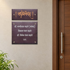 Hrishikesh and Mahato Family two-panel engraved brown stone nameplate installed beside an apartment entrance, preserving the gap between slabs