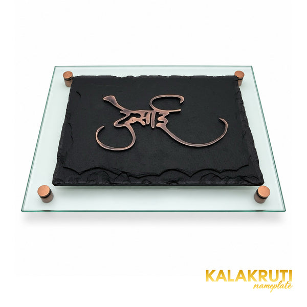Desai black stone and antique copper nameplate, low tabletop view showing the green-tinted glass backing and stud depth