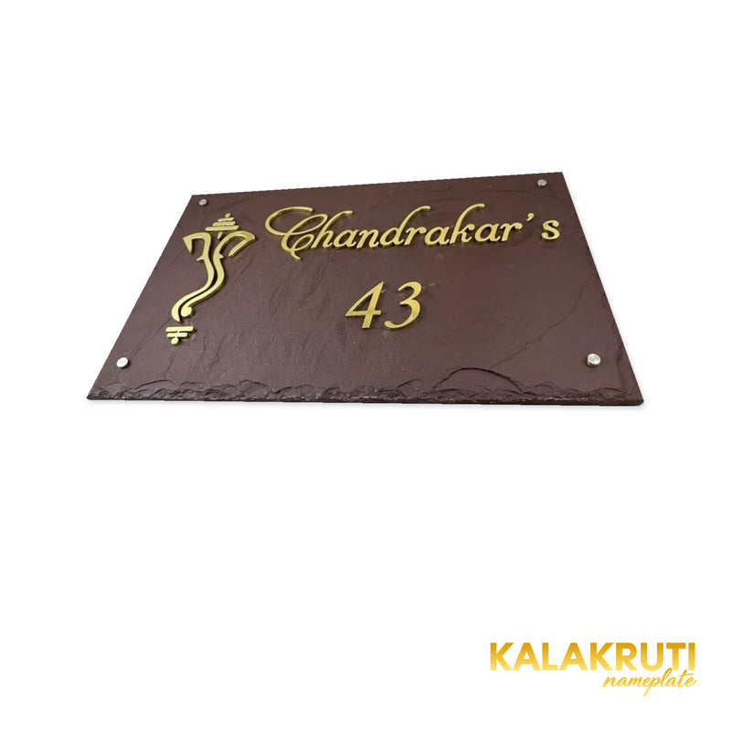 Chandrakar nameplate, low tabletop view showing brass lettering depth on a white studio background