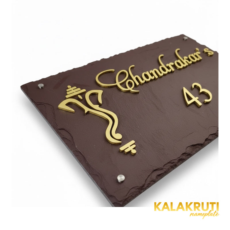 Chandrakar brown stone nameplate, close detail of the raised brass Ganesha motif, script and chipped rim