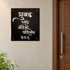Bhuvad Family nameplate shown installed beside an indoor apartment entrance door