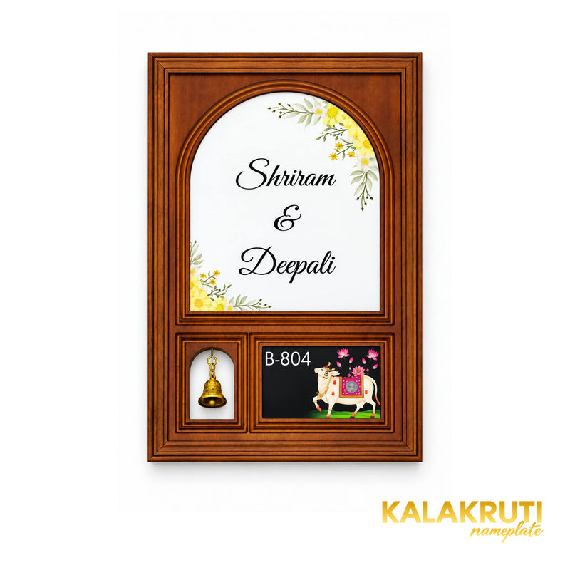 Straight-on view of the brown wooden frame, white floral acrylic name arch, open bell window and printed cow panel reading B-804.